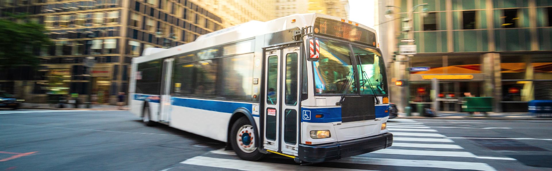 City public transportation traveling in on the city streets making stops to drop off and pick up commuters.
